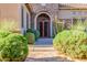 Arched metal security door and desert landscaping create a charming entrance at 10934 E La Verna Way, Scottsdale, AZ 85262