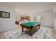 Open-concept game room featuring a pool table, with a view of a kitchen area and ample natural light at 10934 E La Verna Way, Scottsdale, AZ 85262