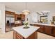 Bright kitchen boasts stainless appliances, white countertops, wood cabinets, and island, with an open view to the living room at 10934 E La Verna Way, Scottsdale, AZ 85262