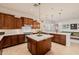 Beautiful kitchen featuring dark wood cabinetry, a center island, and stainless steel appliances at 10934 E La Verna Way, Scottsdale, AZ 85262
