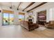 Bright living room featuring wood beam ceiling, a stone fireplace, and access to a backyard pool at 10934 E La Verna Way, Scottsdale, AZ 85262