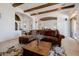 Spacious living room featuring wood beam ceiling, stylish furniture, and an open floor plan at 10934 E La Verna Way, Scottsdale, AZ 85262