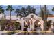 Charming Spanish Village entrance with stucco archway, lush desert landscaping, shops and restaurant at 10934 E La Verna Way, Scottsdale, AZ 85262