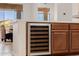 Built-in wine fridge with custom cabinetry and white countertops, located near a window with a view at 10934 E La Verna Way, Scottsdale, AZ 85262