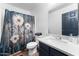 Inviting bathroom with a vanity, a stylish shower curtain, and well-placed fixtures, enhancing the home's functionality at 10939 W Meadowbrook Ave, Phoenix, AZ 85037