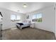 Bright bedroom with two windows, carpet flooring, and a comfortable bed at 10939 W Meadowbrook Ave, Phoenix, AZ 85037