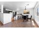 Bright kitchen with black countertops, black bar stools, pendant lighting, adjacent to an eating area, promoting modern comfort at 10939 W Meadowbrook Ave, Phoenix, AZ 85037