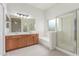 Bathroom features a large mirror, double sinks, a bathtub, and a walk-in shower with glass door at 11010 W Palm Ln, Avondale, AZ 85392