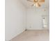 Bright, carpeted bedroom featuring a ceiling fan and access to other areas of the home at 11010 W Palm Ln, Avondale, AZ 85392