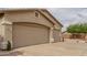 Angle view showing a three-car garage, neutral stucco, low maintenance landscaping and a tile roof at 11010 W Palm Ln, Avondale, AZ 85392