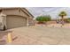 Angle view showing a three-car garage, neutral stucco, low maintenance landscaping and a tile roof at 11010 W Palm Ln, Avondale, AZ 85392