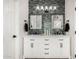 Modern bathroom featuring double sinks, white cabinetry, black hardware, and unique glass tile accent wall at 1144 W Tremaine Ave, Gilbert, AZ 85233