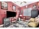 The cozy bedroom features red walls, a ceiling fan and a large TV at 1144 W Tremaine Ave, Gilbert, AZ 85233