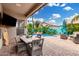 Inviting patio with outdoor dining, lush landscaping, pool view, and cozy seating area at 1144 W Tremaine Ave, Gilbert, AZ 85233