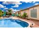 Inviting backyard oasis boasts a private pool, brick-paved patio, and lush tropical landscaping at 1144 W Tremaine Ave, Gilbert, AZ 85233