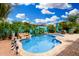 Inviting pool area featuring rock waterfall, mature palm trees, and ample space for outdoor seating at 1144 W Tremaine Ave, Gilbert, AZ 85233