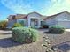 Single-story home boasts desert landscaping, mature shrubs, and an attached two-car garage for convenience at 1210 E Westchester Dr, Chandler, AZ 85249