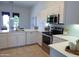 Well-lit kitchen featuring stainless steel appliances, white cabinets, and a view to the outside at 1210 E Westchester Dr, Chandler, AZ 85249