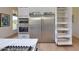 Modern kitchen featuring stainless steel appliances, sleek white cabinetry, and convenient pull-out shelving at 12225 E Cortez Dr, Scottsdale, AZ 85259