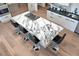 Aerial view of a modern kitchen island with a marble countertop, cooktop, and barstools at 12225 E Cortez Dr, Scottsdale, AZ 85259