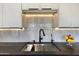 Modern kitchen sink with stainless steel basin and sleek black faucet against light backsplash at 12225 E Cortez Dr, Scottsdale, AZ 85259