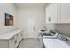 Functional laundry room with white cabinets, countertops, sink, and modern appliances at 12225 E Cortez Dr, Scottsdale, AZ 85259