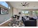 Bright living room with a modern ceiling fan, fireplace, and an expansive view of the beautifully landscaped exterior at 12225 E Cortez Dr, Scottsdale, AZ 85259