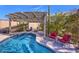 Pool area features blue tile, covered patio, red lounging chairs, and desert landscaping at 12225 E Cortez Dr, Scottsdale, AZ 85259