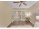 Bedroom with wood floors and ceiling fan offers a view into the open hallway and staircase at 14010 N 126Th Ave, El Mirage, AZ 85335