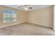 Bright bedroom with a ceiling fan, neutral carpet, and a large window at 14010 N 126Th Ave, El Mirage, AZ 85335