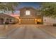 Charming two-story home featuring a spacious driveway, two-car garage, and manicured desert landscaping at 14010 N 126Th Ave, El Mirage, AZ 85335