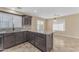 Kitchen boasts an island, granite countertops, dark cabinets, and plenty of natural light from surrounding windows at 14010 N 126Th Ave, El Mirage, AZ 85335