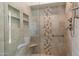 Modern tiled shower stall features custom tiled design, and built-in shower caddy shelves at 14248 N 56Th Pl, Scottsdale, AZ 85254