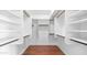 Spacious walk-in closet with custom white shelving and hardwood floors at 14248 N 56Th Pl, Scottsdale, AZ 85254