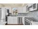 Updated kitchen with white cabinets, stainless steel appliances, mosaic tile backsplash, and a modern sink at 14248 N 56Th Pl, Scottsdale, AZ 85254