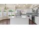 Bright kitchen featuring white cabinets, stainless steel appliances, a large island, and a mosaic tile backsplash at 14248 N 56Th Pl, Scottsdale, AZ 85254