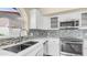 Updated kitchen featuring white cabinets, stainless steel appliances, and a mosaic backsplash, creating a modern culinary space at 14248 N 56Th Pl, Scottsdale, AZ 85254