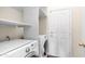 Well-equipped laundry room featuring a washer and dryer, as well as overhead shelving at 14248 N 56Th Pl, Scottsdale, AZ 85254