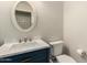 Stylish powder room featuring modern fixtures, marble countertops, navy vanity, and decorative mirror at 15010 W Hope Dr, Surprise, AZ 85379