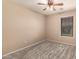 Neutral carpeted bedroom featuring a ceiling fan with light and a window with wood blinds at 15010 W Hope Dr, Surprise, AZ 85379