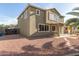 Back exterior showcasing desert landscaping, a covered patio, and a two-story house design at 15010 W Hope Dr, Surprise, AZ 85379