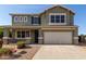 Inviting two-story home featuring a two-car garage and a charming front porch with decorative stone accents at 15010 W Hope Dr, Surprise, AZ 85379