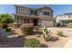 Beautiful two-story home with a well-manicured front yard, desert landscaping, and a spacious two-car garage at 15010 W Hope Dr, Surprise, AZ 85379