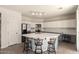 Bright eat-in kitchen boasts granite countertops, stainless steel appliances, island with bar seating, and ample cabinet space at 15010 W Hope Dr, Surprise, AZ 85379