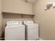 Functional laundry room equipped with a washer, dryer, and shelf, providing convenience at 15010 W Hope Dr, Surprise, AZ 85379