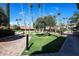 Community courtyard featuring lush greenery, olive trees, and paver walkways at 17404 N 99Th Ave # 318, Sun City, AZ 85373