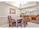 Elegant dining room featuring a chandelier, seating for six, and a mirrored buffet at 17404 N 99Th Ave # 318, Sun City, AZ 85373