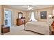 Spacious bedroom with carpet, a decorative wood bed frame, and ensuite bathroom access at 17404 N 99Th Ave # 318, Sun City, AZ 85373