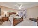 Comfortable bedroom with carpet, a decorative wood bed frame, and ceiling fan at 17404 N 99Th Ave # 318, Sun City, AZ 85373
