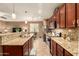 Open kitchen featuring granite counters, wooden cabinets, stainless steel appliances, and bar seating at 17797 W Statler Dr, Surprise, AZ 85388